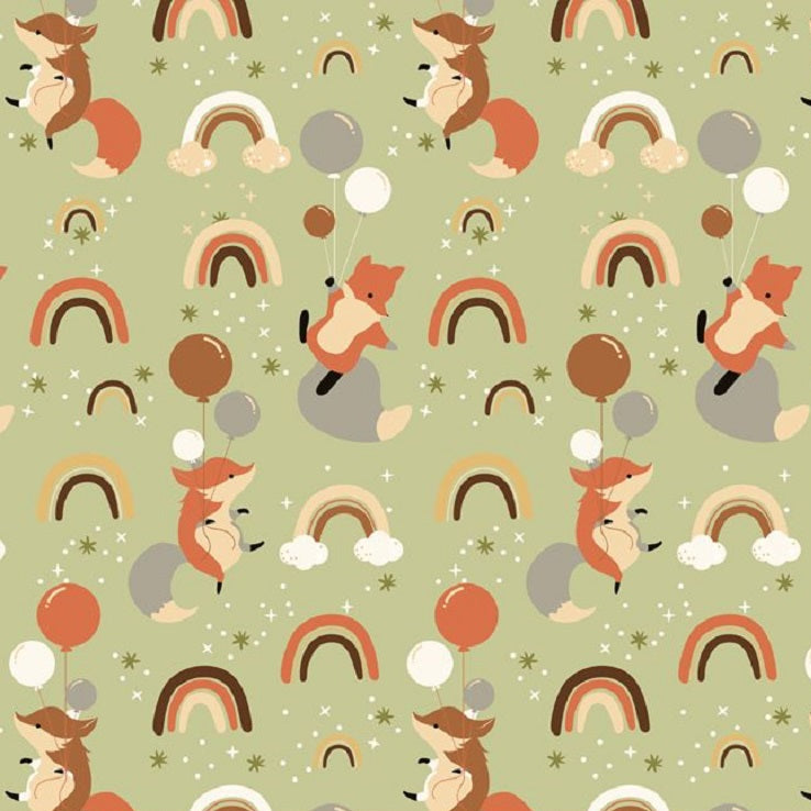 Patterned fabric with foxes, rainbows, and balloons on a green background, ruler at the bottom for scale.