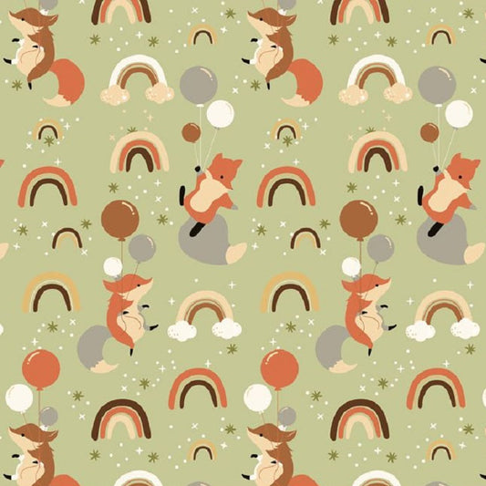 Patterned fabric with foxes, rainbows, and balloons on a green background, ruler at the bottom for scale.