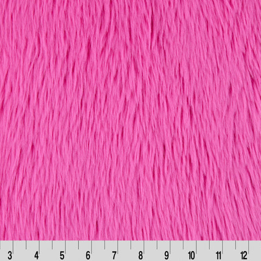 Pink furry fabric with a ruler at the bottom for scale.