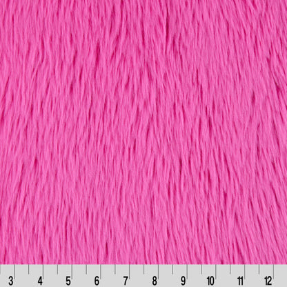 Pink furry fabric with a ruler at the bottom for scale.